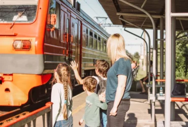 Kinder am Bahnsteig Zug fährt ein