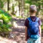 Junge mit Wanderrucksack im Wald