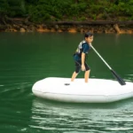 Kleiner Junge paddelt mit dem Schlauchboot