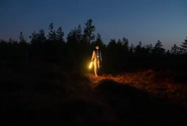 Frau bei Nacht im Wald beim Wandern